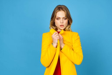 Sarı ceketli kadın makyajlı mavi arka plan