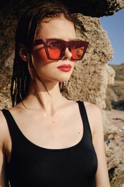 Güneş gözlüğü takan kadın taş dağıtıyor.