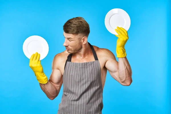 Hombre alegre en delantales lavar los platos de las tareas domésticas fondo azul — Foto de Stock