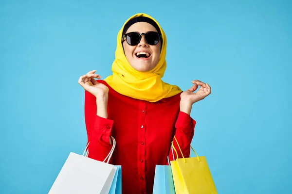 Tesettürlü Müslüman kadın alışveriş eğlencesi mavi arka plan — Stok fotoğraf