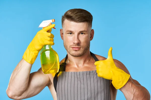 Man met een schort schoonmaakmiddel huishoudelijk werk — Stockfoto