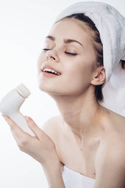 Kafasına havlu geçirmiş güzel bir kadın. Yüz masajı yaptırıyor.