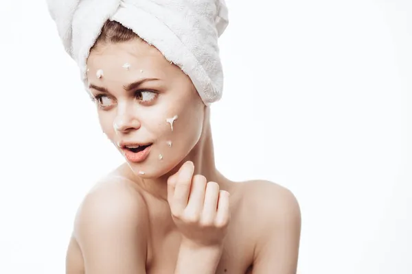 Wanita ceria dengan handuk putih di kepalanya wajah krim perawatan kulit — Stok Foto