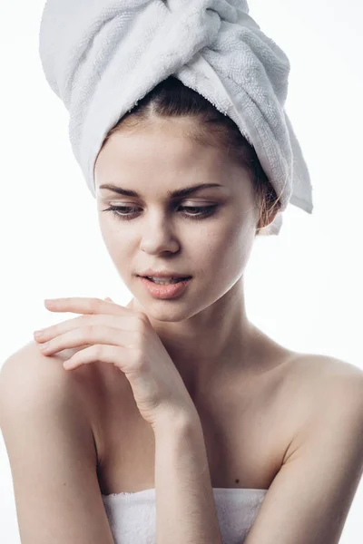 Žena po sprše s ručníkem na hlavě představuje péči o pleť — Stock fotografie