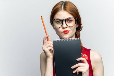 Gözlüklü kadın sekreter ve müdürün elinde bir defter.