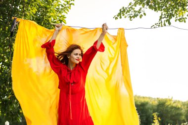 Elleri sarı kumaşlı, kırmızı elbiseli kadın.