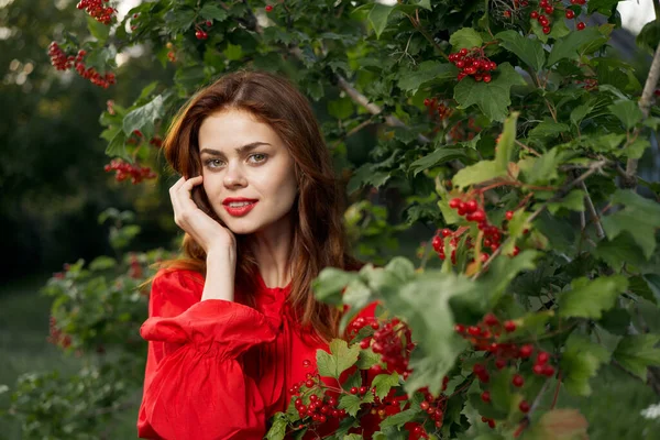 Vacker kvinna i röd klänning gröna löv natur sommar — Stockfoto