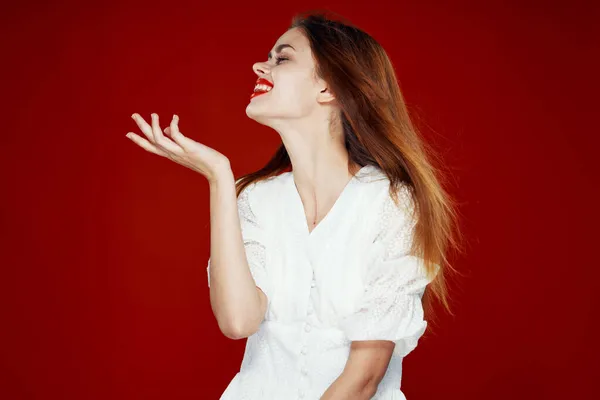 Cheerful red-haired woman with red lips white dress red background — Stock Photo, Image