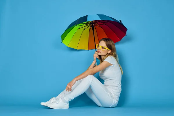 Femme à la mode avec des couleurs parapluie arc-en-ciel posant fond bleu — Photo
