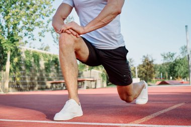 Adam dışarıda oyun sahasında egzersiz yapıyor.