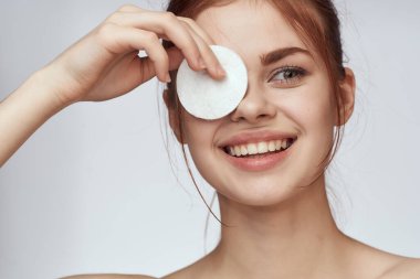 Pamuklu ped ve temiz cilt bakımı cazibesi olan güzel bir kadın.