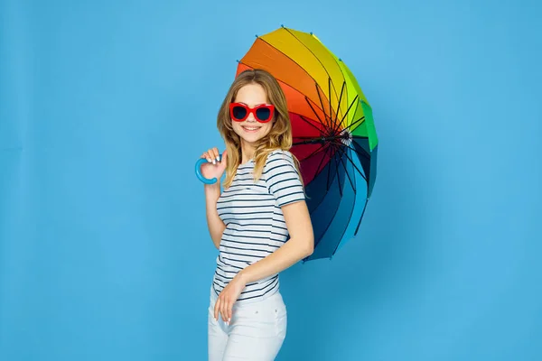 漂亮的女人打扮成五彩缤纷的雨伞蓝色背景 — 图库照片