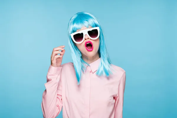 Atrakcyjna kobieta w fioletowe peruki okulary model niebieski tło — Zdjęcie stockowe