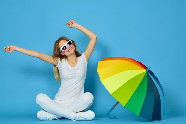 Fashionabla kvinna med paraply regnbåge färger poserar blå bakgrund — Stockfoto