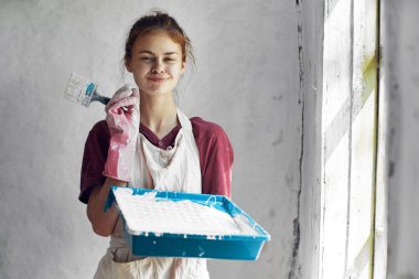 Elinde fırça olan neşeli kadın ressam ev dekorasyonu yaratıcı.