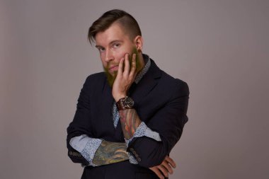 Ceketli sakallı adam profesyonel poz veriyor.