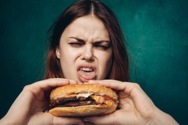 Hamburger yiyen bir kadın.