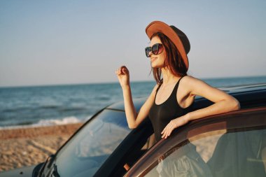 Kadın plajda araba yolculuğunun yanında yaz tatili