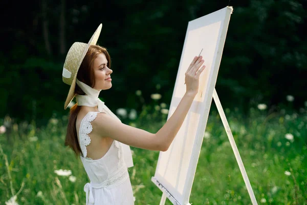 Frau in weißem Kleid in der Natur malt Bild eines Landschaftshobby — Stockfoto
