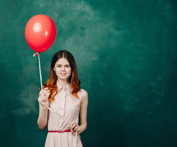 Hübsche Frau im Kleid roten Ballon Urlaub grünen Hintergrund — Stockfoto