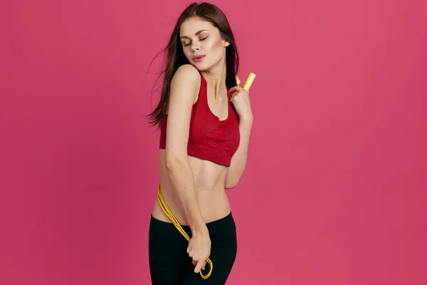 Atletisk kvinna träning hälsa smal figur rosa bakgrund — Stockfoto