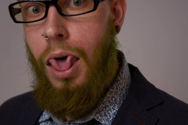 Gözlüklü ve sakallı bir iş adamının resmi poz veren portresi.