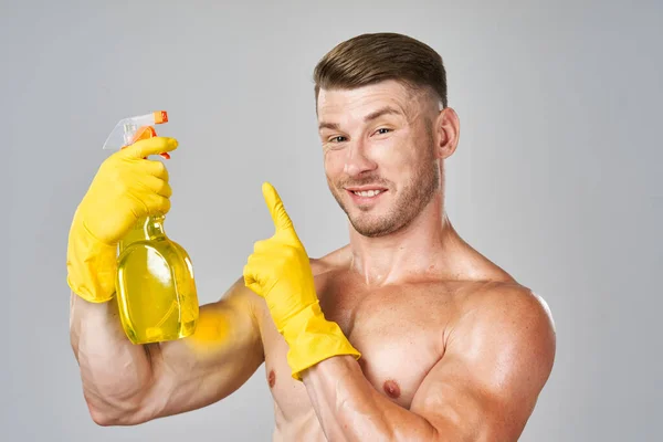 Male naked torso wearing rubber gloves cleaning supplies housework isolated background — стоковое фото