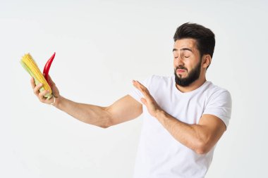 Elinde sebzelerle sakallı bir adam. Sıcak biberli mısır.