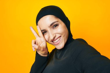 Neşeli kadın, mutluluk, moda, el hareketi, sarı arka plan.