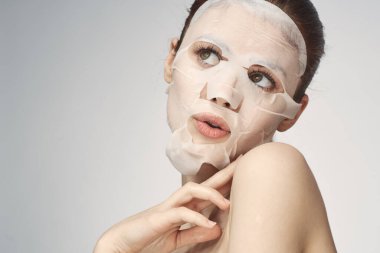Çıplak omuzlu kadın maske takıyor.