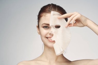 Çıplak omuzlu kadın maske takıyor.