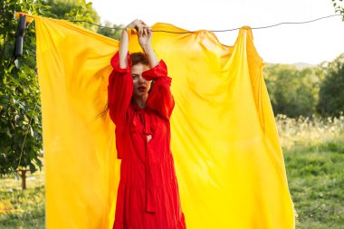 Kırmızı elbiseli duygusal kadın. Sarı arka plan pozu.