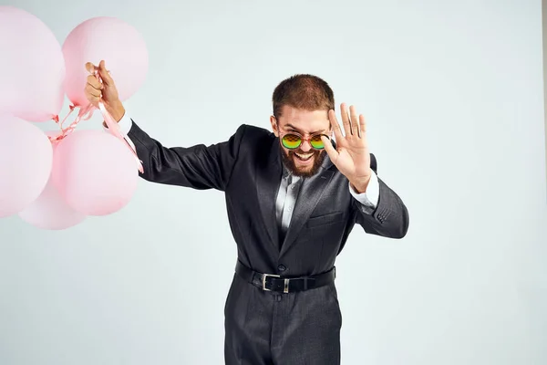 Чоловік у костюмі та сонцезахисних окулярах рожеві кульки менеджера свята — стокове фото