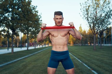 Parktaki spor salonunda mavi şortlu bir adam.