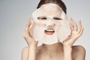 Çıplak omuzlu kadın maske takıyor.