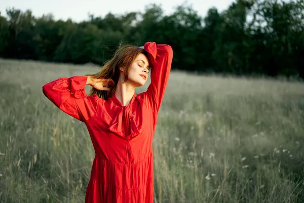 Pretty woman in red dress in field nature posing landscape — Stock Photo, Image
