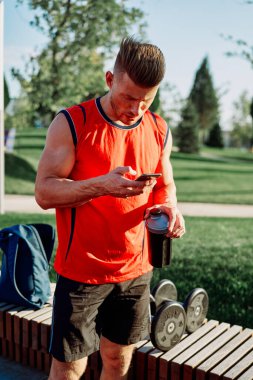 Spor salonunda kırmızı tişörtlü bir sporcu.