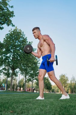 Parktaki sportif adam Crossfit egzersizi yapıyor.