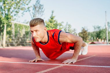 Spor sahası egzersizlerinde kaslı sporcular.