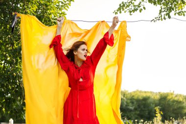 Elleri sarı kumaşlı, kırmızı elbiseli kadın.