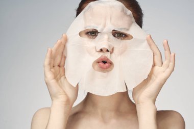 Çıplak omuzlu kadın maske takıyor.