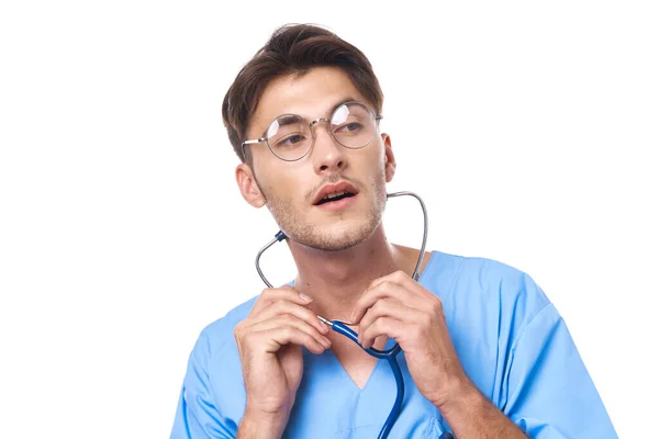 Uomo in uniforme medica indossando occhiali stetoscopio posa sfondo isolato — Foto Stock