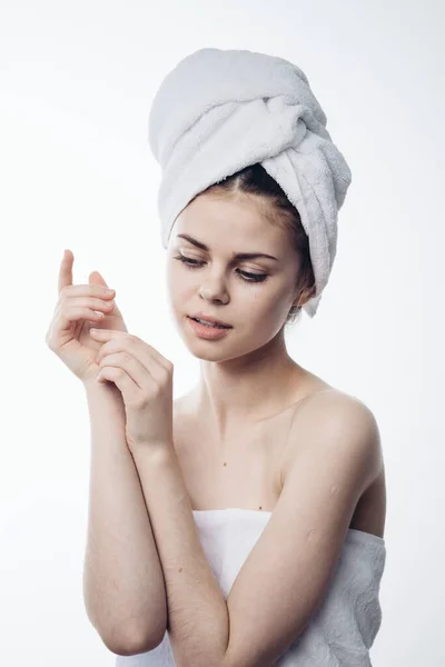 Женщина после душа с полотенцем на голове, позируя уход за кожей — стоковое фото