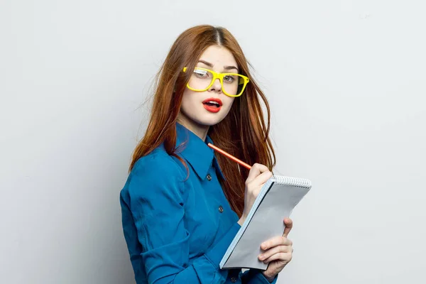 Femme d'affaires avec bloc-notes et crayon portant des lunettes jaunes bureau professionnel — Photo