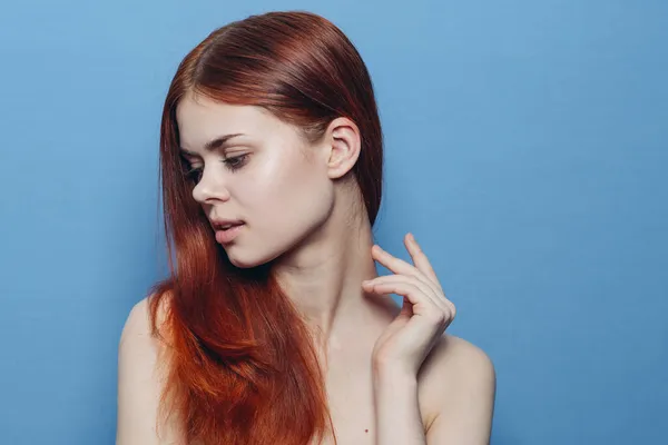 Rödhårig kvinna nakna axlar hårvård blå bakgrund — Stockfoto