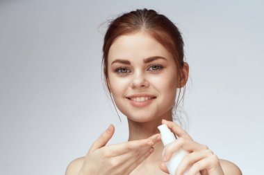 Ellerinde losyon olan kadın cilt bakımını temizliyor.