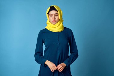 Sarı tesettürlü kadın teknoloji hesap makinesi finans işlerinde çalışıyor.