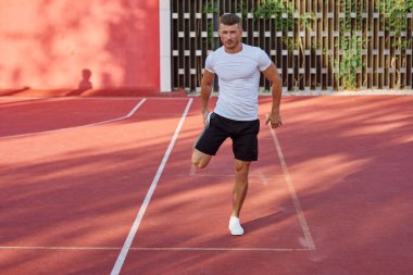 Spor sahası motivasyonunda beyaz tişörtlü adam.