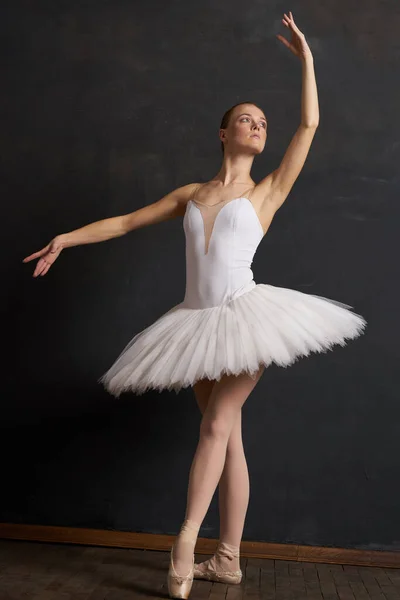 Bailarina de mujer en un tutú blanco danza posando rendimiento fondo oscuro —  Fotos de Stock