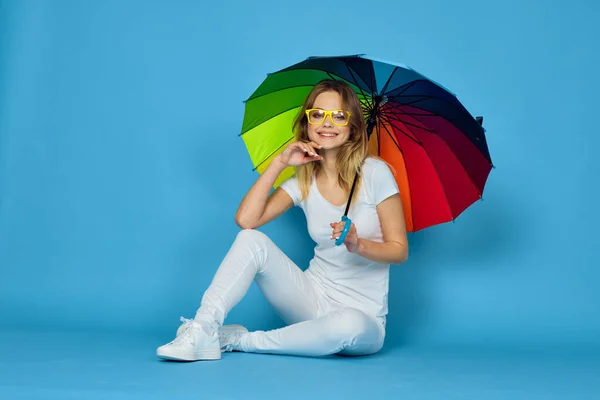 Donna alla moda con ombrello arcobaleno colori posa sfondo blu — Foto Stock